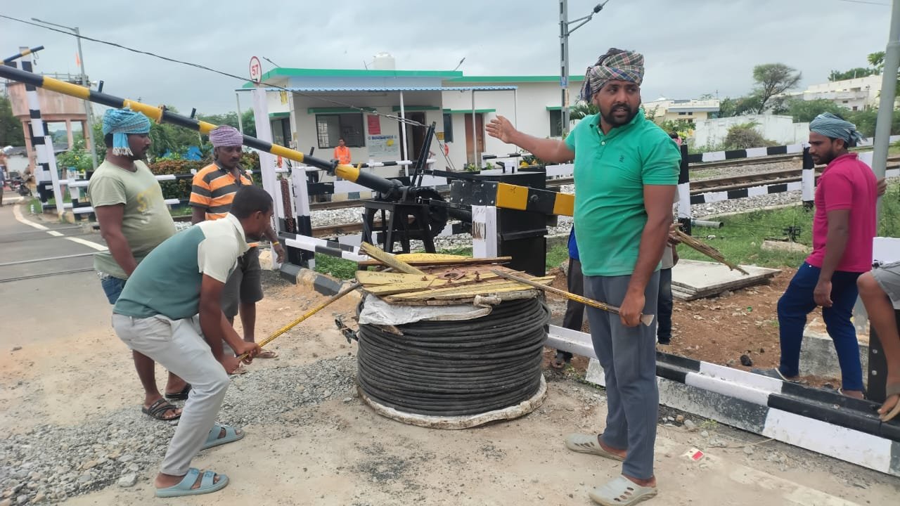Team laying cable at railway crossing